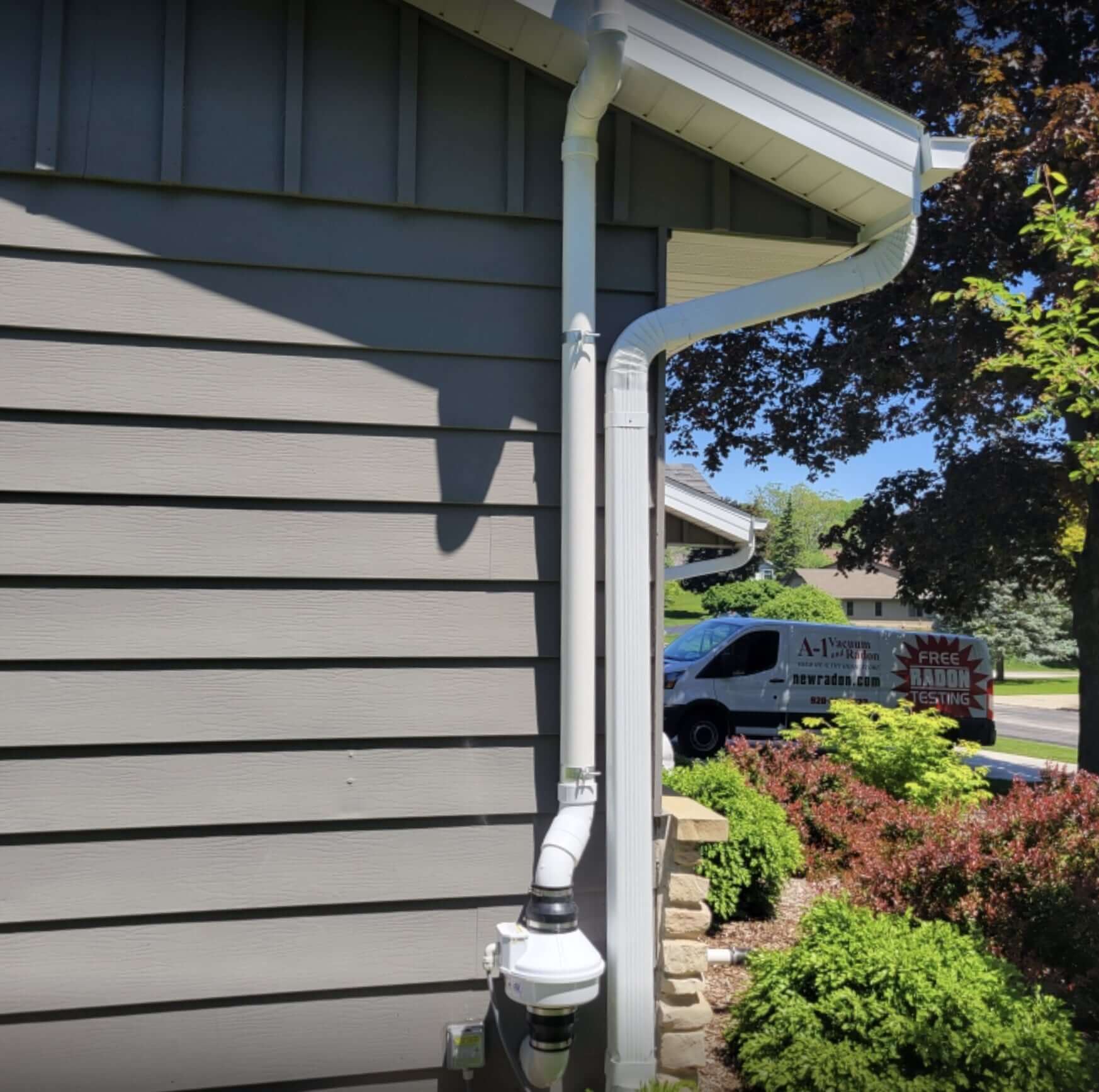 Radon mitigation system expertly installed at a local home, with visible vent pipe and fan ensuring safe removal of radon gas